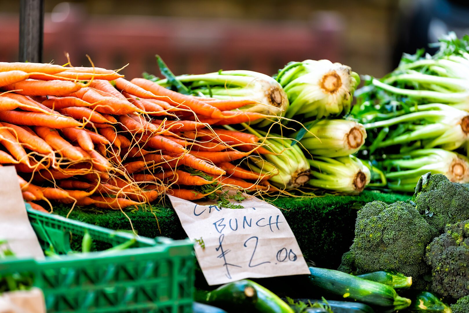 A bunch of carrots and other vegetables on display.