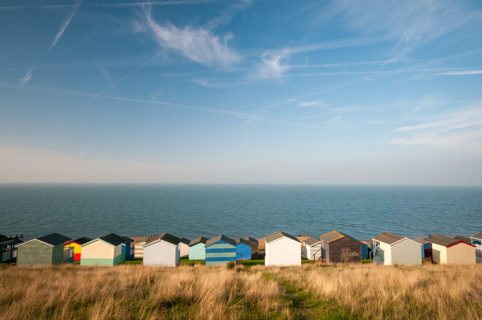 Colourful beach huts against a cloudy sky