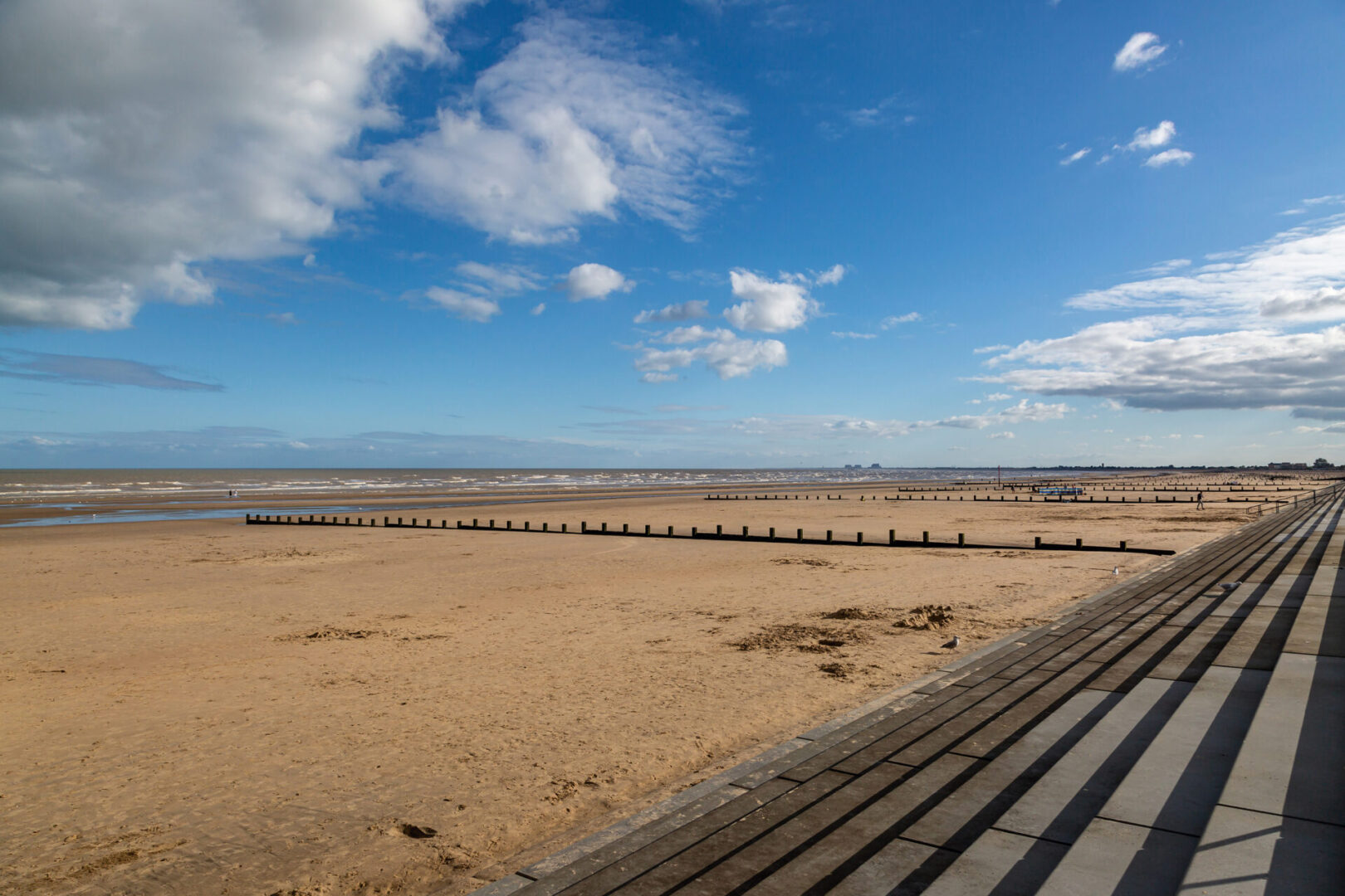 A beach with wooden steps and sand dunes.