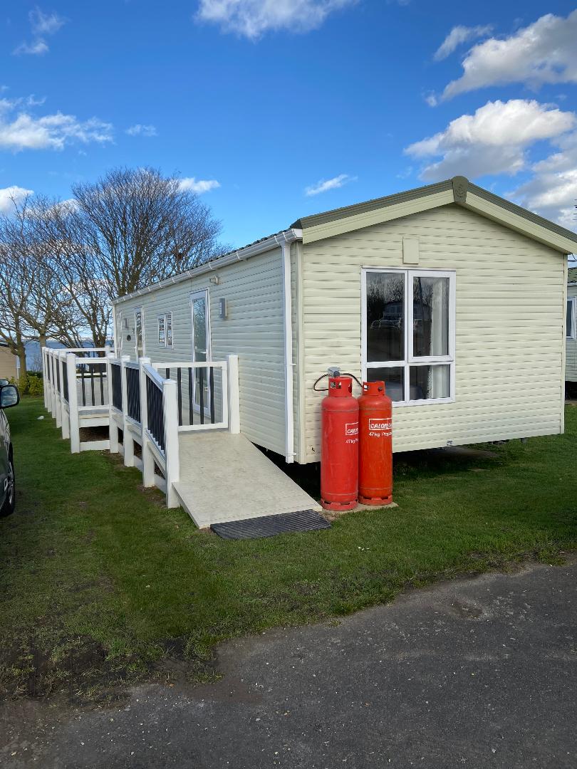 A white mobile home with stairs leading to the front.