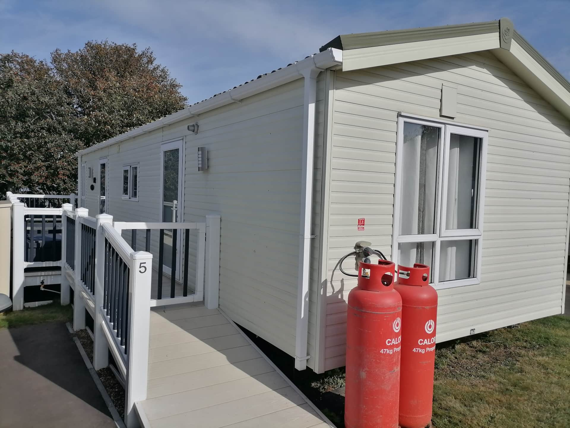 A white house with two red gas tanks.